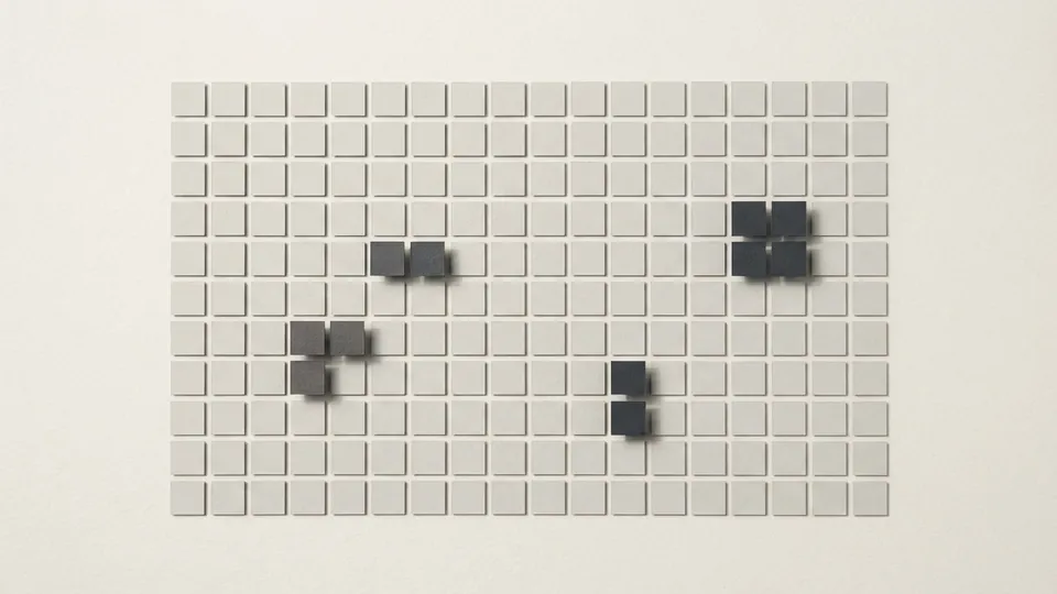 A large grid of flat pale paper tiles with only a few dark graphite tiles raised above the rest